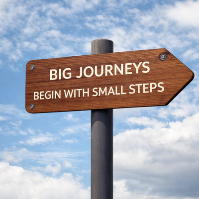 Indicator cu mesajul Big journeys begin with small steps simbolizând progresul strategic în business coaching pentru antreprenori și lideri